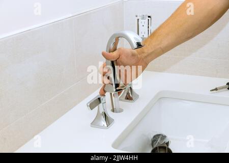 Klempner montieren und installieren Wasserhahn im Badezimmer Stockfoto