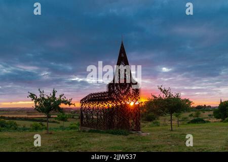 Herrlicher Sonnenuntergang über Wiesen in Belgien Limburg in der Nähe der Borgloon. Mit spektakulären Farben durch die Kirche als Reading zwischen den Zeilen bekannt gesehen Stockfoto