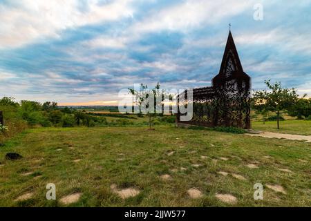 Herrlicher Sonnenuntergang über Wiesen in Belgien Limburg in der Nähe der Borgloon. Mit spektakulären Farben durch die Kirche als Reading zwischen den Zeilen bekannt gesehen Stockfoto