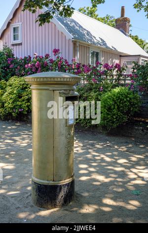 Der ehemals blaue Briefkasten auf der Insel Sark in der Bailiwick von Guernsey wurde von Guernsey Post zum Gedenken an Carl Hesters Gold meda mit Gold bemalt Stockfoto