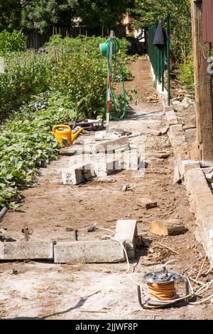 Ersetzt den alten Gartenzaun durch einen neuen. Bau neuer Maschendrahtzaun im Garten des Hauses Stockfoto
