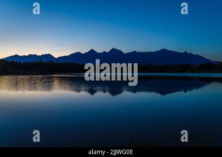 Sonnenuntergang über einem Bergsee und Tatra im Hintergrund Stockfoto