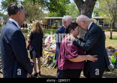 Uvalde, Vereinigte Staaten von Amerika. 29. Mai 2022. US-Präsident Joe Biden tröstet die Direktorin Mandy Gutierrez als Superintendent Hal Harrell, während sie vor der Robb Elementary School am 29. Mai 2022 in Uvalde, Texas, an einem provisorischen Denkmal Halt machen, um ihren Respekt zu zollen. Die Schule ist der Ort, an dem ein Schütze 19 Schüler und zwei Lehrer mit einem militärischen Sturmgewehr abschlachtete. Bild: Adam Schultz/White House Photo/Alamy Live News Stockfoto