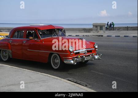 Vintage Red 1950 Cadillac Roadmaster Oldtimer mit verchromtem Stoßfänger, Grill, Scheinwerfern und kubanischen Platten auf der Malecón Esplanade Havana, Kuba. Stockfoto