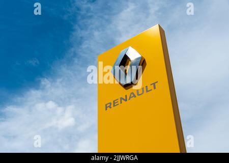 Zeichen des französischen Automobilherstellerkonzerns Renault mit seinem diamantförmigen Logo auf gelbem Hintergrund Stockfoto