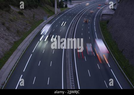 Lichter von Autos und Lastwagen, die auf der Autobahn rasenden Stockfoto