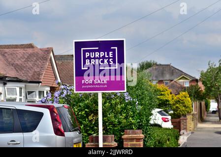 Ein 'Purple Bricks' Online-Immobilienmakler zum Verkauf Zeichen vor einem Vorstadthaus in Shepperton Surrey UK Stockfoto