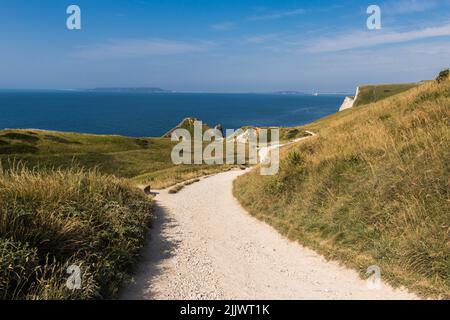 Steiler Fußweg, der zur Durdle Door (manchmal Durdle Dor) führt, ist ein natürlicher Kalksteinbogen an der Jurassic Coast in der Nähe von Lulworth in Dorset Stockfoto