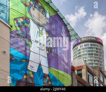 Ein riesiger Bildschirm bedeckt ein Gebäude mit einem Bild von Perry, dem Stier, Maskottchen der Commonwealth Games von Birmingham 2022. Dahinter steht die ikonische Rotunde. Stockfoto