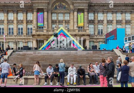 Besucher des Stadtzentrums von Birmingham sitzen vor der Floozie im Whirlpool und im Rathaus von Birmingham. Stockfoto