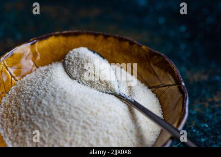 Bio-Maismehl in der Keramikschale auf dem Steintisch Stockfoto