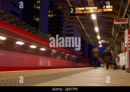 Eine Nachtaufnahme mit langsamer Verschlusszeit vom Bahnhof in der Docklands-Gegend von London, Großbritannien Stockfoto