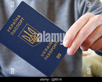 Ukrainischer biometrischer Pass in der Hand seines Besitzers Stockfoto