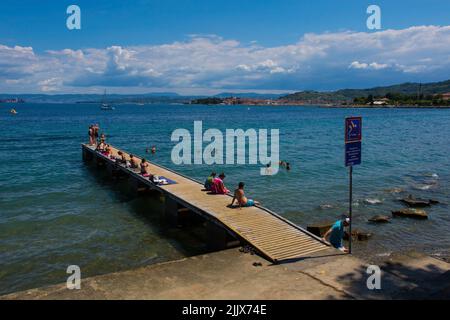 Izola, Sovenia - 10.. Juli 2022. Einheimische und Touristen genießen die Sonne an der slowenischen Adriaküste in der Nähe von Izola Stockfoto