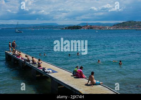 Izola, Sovenia - 10.. Juli 2022. Einheimische und Touristen genießen die Sonne an der slowenischen Adriaküste in der Nähe von Izola Stockfoto