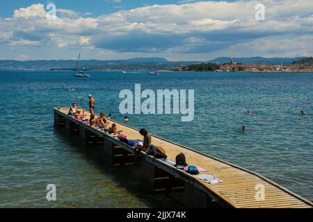 Izola, Sovenia - 10.. Juli 2022. Einheimische und Touristen genießen die Sonne an der slowenischen Adriaküste in der Nähe von Izola Stockfoto