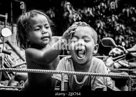 Das Sea Gipsy Village in Phuket Thailand, Moken Kinder spielen draußen. Schwarzweiß-Foto Stockfoto