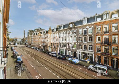 Von oben Haus außen gegen Fahrbahn und geparkte Fahrräder und Autos tagsüber in Amsterdam Holland Stockfoto