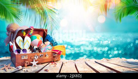 Reisekoffer Am Tropischen Strand Mit Sonnigem Meer Und Palmenblättern - Unscharfer Abstrakter Hintergrund Stockfoto