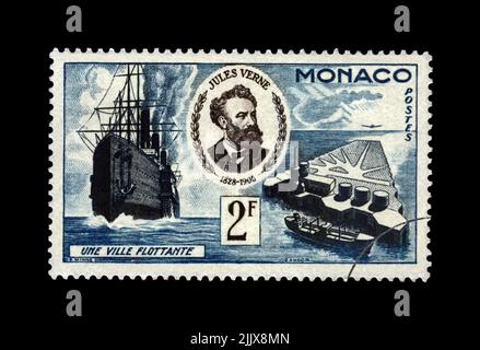Jules Verne (1828-1905), berühmter Wissenschaftsschriftsteller und schwimmende Stadt, um 1955. Abgesagte Briefmarke gedruckt in Monaco isoliert auf schwarzem Hintergrund. Stockfoto