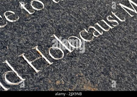 holocaust-Gedenkbotschaft auf Granitwand in Nahaufnahme, Konzentrationslager-Befreiungsvielfalt Stockfoto