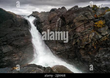 Mächtiger landschaftlicher Wasserfall unter dramatischem Himmel. Stuor Muorkke Wasserfall im Stora Sjofallet Nationalpark, Schweden. Abenteuer in arktischer Wildnis. Herbst Stockfoto