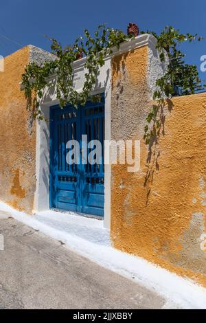 Traditionelle griechische hellblaue Tür gegen eine orangefarbene Wand in Akrotiri, Santorini, Kykladen-Inseln, Griechenland, Europa Stockfoto