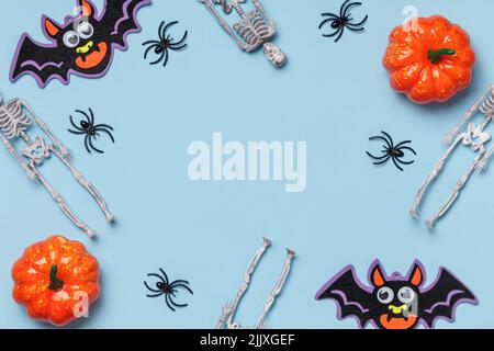 Halloween-Konzept. Festliche Einrichtungsgegenstände auf blauem Hintergrund. Flach, oben liegend, Kopieplatz Stockfoto