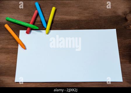 Bunt viele Buntstifte und weißes Papier auf Holz Stockfoto
