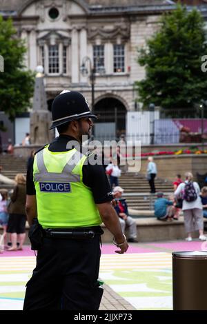 BIRMINGHAM, GROSSBRITANNIEN - 28. JULI 2022. Eine Rückansicht eines asiatischen Polizisten in Uniform auf der Straße einer britischen Stadt, der Vielfalt in der Polizei zeigt Stockfoto