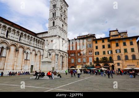 Chiesa di San Michele in Foro, Basilika auf der Piazza di San Michele mit vorbeiziehenden Menschen, Zentrum von Lucca, Toskana, Italien. Stockfoto