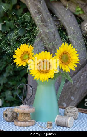 Bouquet von Sonnenblumen und Gräsern in Vintage-Krug Stockfoto