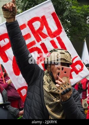 Eine afro-Nachfahrin mit Helm gestikuliert und schreit, als sich am Unabhängigkeitstag Perus Hunderte auf den Straßen versammeln, um gegen Präsident Pedro Castillo zu protestieren, der nach dem ersten Jahr seiner Herrschaft verschiedenen Korruptionshandlungen beschuldigt wird. Stockfoto