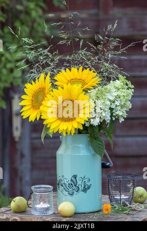 Bouquet von Sonnenblumen, Hortensien und Gräsern in Jahrgangsmilchbüsche Stockfoto