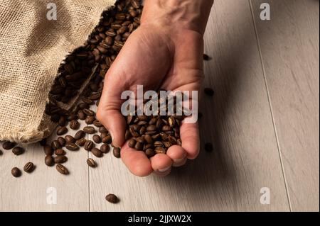 Eine Handvoll gerösteter Kaffeebohnen mit Platz zum Kopieren Stockfoto