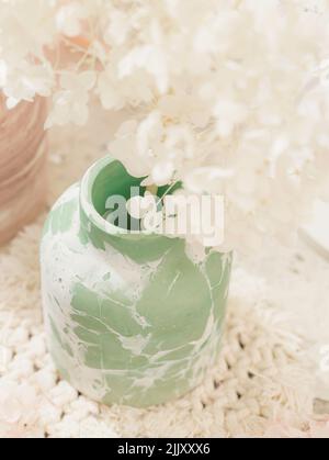 Grüne Vase aus Gips mit einem Bukett aus stabilisiertem Lavendel. Minimalistisches Innendesign. Kinfolk, Hygge, skandinavischer Stil, Lagom. Kuscheliges Design. Co Stockfoto