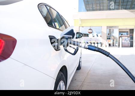 Pumpen von Gas an der Gaspumpe Nahaufnahme des Menschen, der Benzin in das Auto pumpt, an der Tankstelle, steigende Benzinpreise, Copy Space. Stockfoto