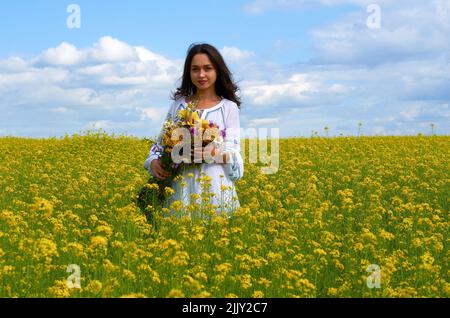 Ein Mädchen in der Nationaltracht der Ukraine in einem Blumenfeld Stockfoto