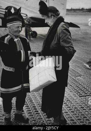 Der malerische Laplander in nativer Tracht schüttelt sich am Flughafen Rovaniemi, Finnland, die Hände von Frau Roosevelt. Elliott, Jr., gab während des Aufenthalts eine leichte Beschwerde aus: Er bekam nicht genug Schlaf, "weil die Sonne um vier Uhr morgens in meinen Augen schien." Er weigerte sich jedoch zu glauben, dass Laplanders überwintern würde, "genau wie Bären". 11. Oktober 1950. Stockfoto