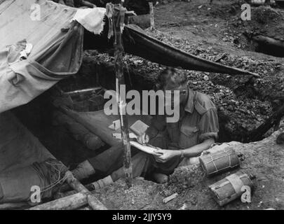 Private J.N. Harris (Bathurst, N.S.W.) schreibt von seinem Mann in einem vorderen Bataillongebiet in der Nähe von Maprik in Neuguinea nach Hause. 25. Juli 1945. (Foto von Australian Official Photo). Stockfoto