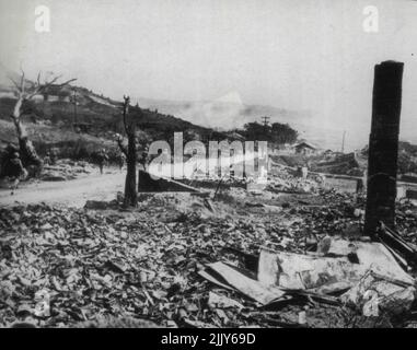 Yanks dringen in die zerschlagene Naha vor: Eine Reihe von Lederhals der sechsten Division marschiert an Bauschutt vorbei in die zerrüttete Stadt Naha, einst eine Hauptstadt mit 66.000 Einwohnern, während der Drang zur vollständigen Eroberung von Okinawa fortgesetzt wird. 28.Mai 1945. (Foto von AP Wirephoto). Stockfoto