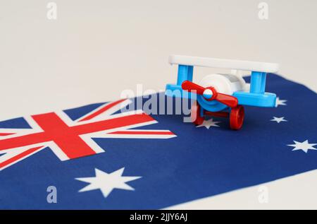 Ein Spielzeug-Flugzeug steht auf der Flagge - Australien. Reise- und Geschäftskonzept Stockfoto