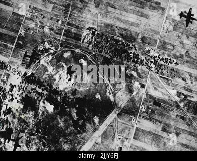 U.S. Bombers Blaster Italienisches Flugfeld in Sardinien: Drei B-26 Marauder-Bomber (links) legen ein Muster von Bombenausbrüchen über das Flugfeld von Alghero auf Sardinien und fangen. Italienische Flugzeuge der US Army Air Forces. Ein weiterer Marauder, der gerade seine Mission abgeschlossen hat, ist oben rechts zu sehen. 02. August 1943. (Foto vom US Office of war Information Picture). Stockfoto