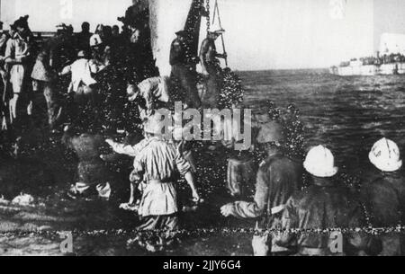 Britain Landing Craft Nehmen Sie eine Ladung italienischer Gefangener auf Italienische Gefangene, die aus ihren Maschinengewehr-Nestern mit Blick auf die sizilianischen Braches gestrahlt wurden, gehen an Bord eines Landungsschiffs auf dem Weg zu einem Gefangenenlager. 06. August 1943. (Foto von British Official Photo). Stockfoto