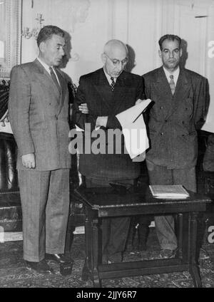 Support Crying Premier - der Premier brach während der Konferenz in Tränen aus. Premier Mossadeq von Persien wird von dem ehemaligen General Kazem Sheybani (links), Und Hossein Makki (rechts), Abgeordneter der nationalen Front und Sekretär des gemeinsamen parlamentarischen Verstaatlichungsrates, liest auf einer Pressekonferenz, die er im Mai 25 in Teheran hielt, eine Erklärung, in der die anglo-iranische Ölgesellschaft der Armut in Persien beschuldigt wird. 28.Mai 1951. (Foto von Associated Press Photo). Stockfoto