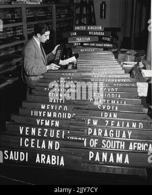 Vorbereitungen Für Den Zweiten Teil Der Generalversammlung Der Vereinten Nationen -- Mit dem 5.. April, dem Eröffnungstermin der zweiten Hälfte der Generalversammlung, wird ein Mitarbeiter der Abteilung für Konferenz und Generaldienste des Sekretariats die Namensschilder, auf denen die Mitgliedstaaten in der Versammlungshalle in Flushing Meadows, New York, identifiziert werden, schnell überprüfen. Der erste Teil der Generalversammlung fand im Palais de Chaillot e Paris statt. 1. März 1949. (Foto von Foto der Vereinten Nationen). Stockfoto