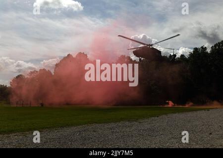 Farbiger Rauch hilft, einen Helikopter der UH-60 Black Hawk zu landen, um einen Soldaten abzusetzen, der am 27. Juli 2022 am Volunteer Training Site-Tullahoma, Tennessee, beim 2022 Best Warrior Competition der Army National Guard teilnimmt. Der Wettbewerb erstreckt sich über fünf körperlich und geistig anspruchsvolle Tage, an denen 14 Teilnehmer um den Titel „Soldat und Unteroffizier des Jahres der Nationalgarde der Armee“ wetteifern. Die Gewinner werden später in diesem Jahr die Armee-Garde im „Department of the Army Best Warrior Competition“ vertreten. (USA Foto der Air National Guard von Meister Sgt. Erich B. Smith) Stockfoto
