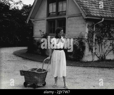 Die Herzogin von Kent und ihre Tochter, Prinzessin Alexandra - die Herzogin von Kent mit Korbflechtwerk-Gartenwagen, pausiert, um eine Zigarette zu rauchen, während sie auf ihre Tochter wartet. 7. September 1954. (Foto von Michael McKeown). Stockfoto