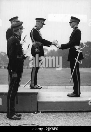 Bester Kadett erhält Ehrenschwert - Feldmarschall Viscount Montgomery, der die Königin vertritt, übergibt dem Senior Under Officer B.L.O Kenny das Ehrenschwert, das er als bester Kadett der Amtszeit an der Royal Military Academy Sandhurst erhält. Die Präsentation fand heute (Donnerstag) auf der Sovereign's Parade statt, bei der die ranghöchsten Kadetten vor Erhalt ihrer Kommissionen vorbeigehen. 5. August 1954. Stockfoto