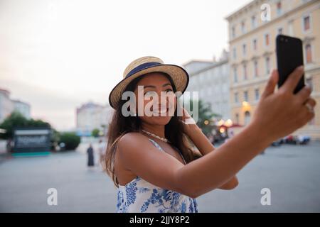 Eine asiatische Touristin macht ein Selfie mit ihrem Smartphone, während sie in Italien Urlaub macht Stockfoto